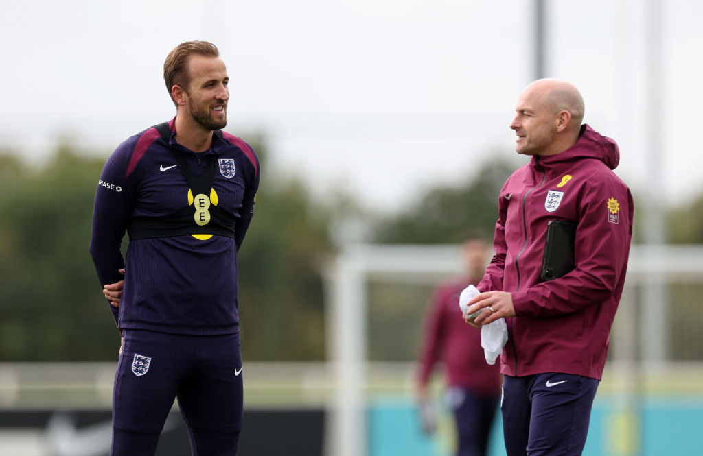 Harry Kane of England and Lee Carsley, Interim Head Coach of England, talk during a training session at St Georges Park