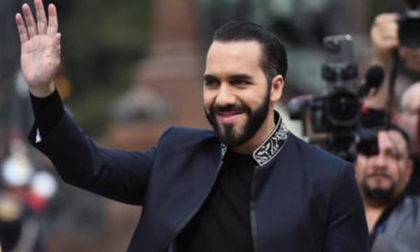 a man dressed in black smiles and waves
