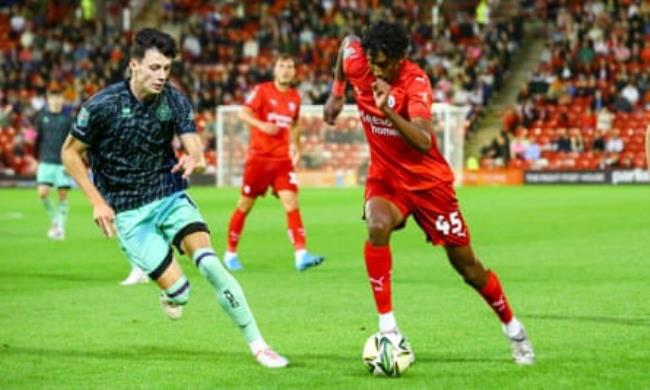 Vimal Yoganathan in red tries to get past Sheffiel United’s Anel Ahmedhodzic in navy
